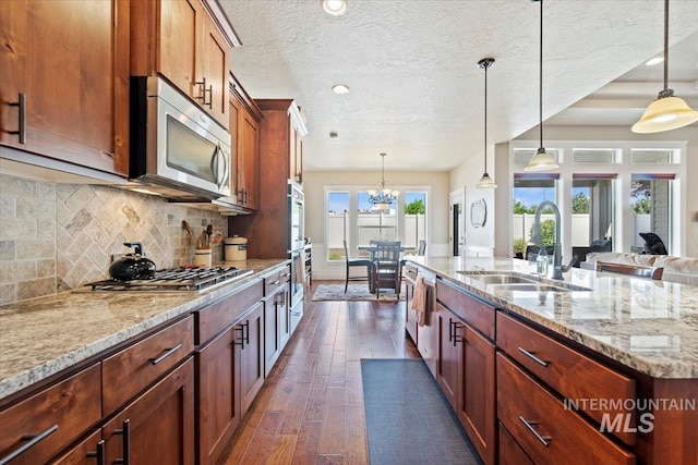 2706 E Rochester Ct, Meridian, ID 83646 - kitchen with a sink, appliances with stainless steel finishes, dark wood-type flooring, light stone countertops, and decorative backsplash