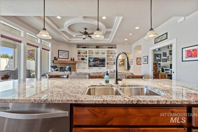2706 E Rochester Ct, Meridian, ID 83646 - kitchen with stainless steel dishwasher, open floor plan, a sink, ceiling fan, and light stone countertops