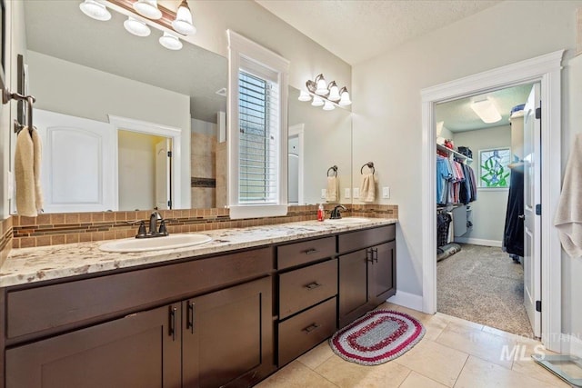 2706 E Rochester Ct, Meridian, ID 83646 - full bathroom featuring backsplash, double vanity, a walk in closet, tile patterned floors, and baseboards