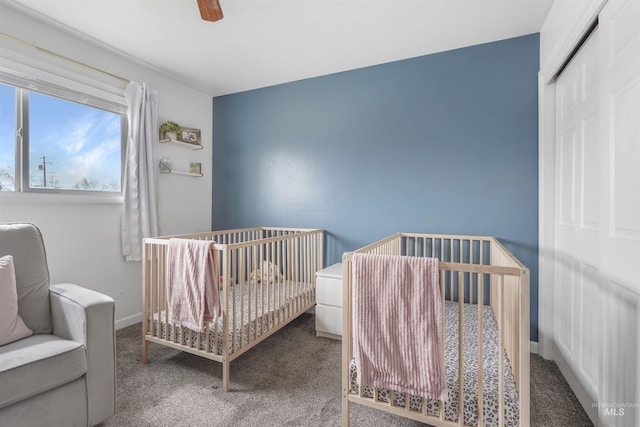 bedroom with ceiling fan, a closet, carpet floors, and a nursery area