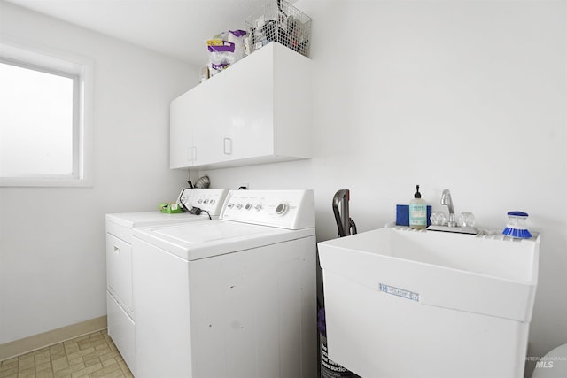 washroom featuring cabinets, washing machine and dryer, and sink