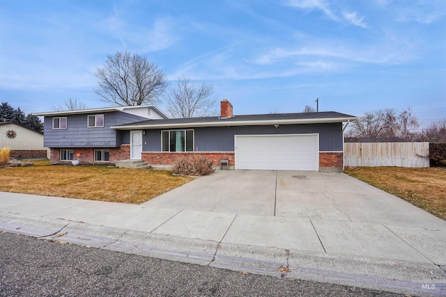 split level home featuring a garage and a front lawn