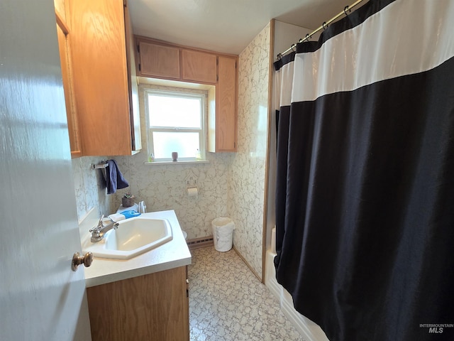 bathroom featuring vanity and wallpapered walls