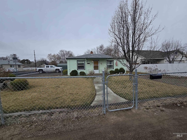 view of front of home featuring a front yard, a gate, a fenced front yard, and a chimney