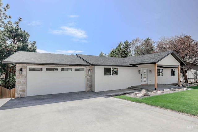 ranch-style home featuring stone siding, a garage, fence, stucco siding, and driveway