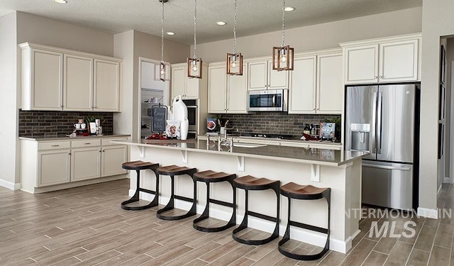 kitchen featuring wood finished floors, backsplash, and stainless steel appliances