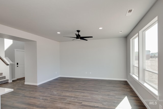 unfurnished room with stairway, baseboards, dark wood-type flooring, and a ceiling fan