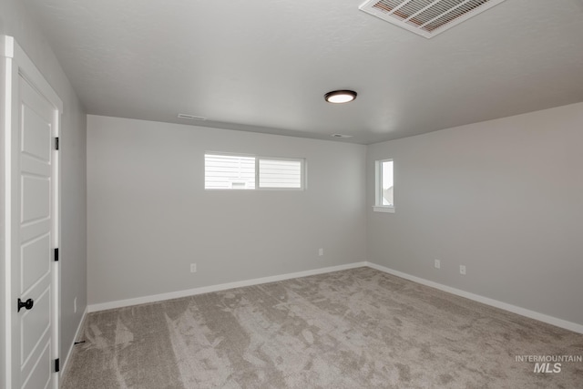 carpeted empty room with visible vents and baseboards