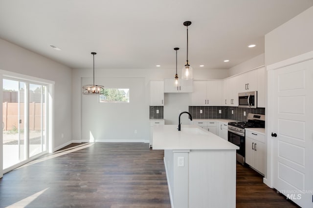 kitchen featuring a sink, tasteful backsplash, dark wood finished floors, stainless steel appliances, and light countertops