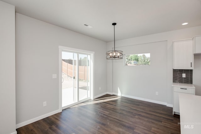 unfurnished dining area featuring visible vents, baseboards, a chandelier, recessed lighting, and dark wood-style floors