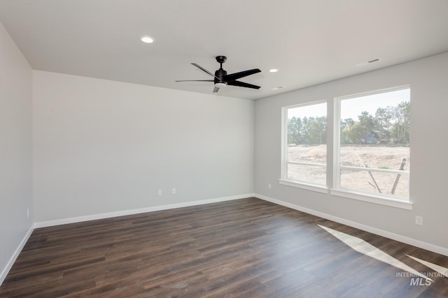 spare room featuring recessed lighting, a ceiling fan, dark wood-type flooring, and baseboards