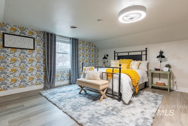1302 1st Ave S, Payette, ID 83661 - bedroom featuring wallpapered walls, wood finished floors, and vaulted ceiling