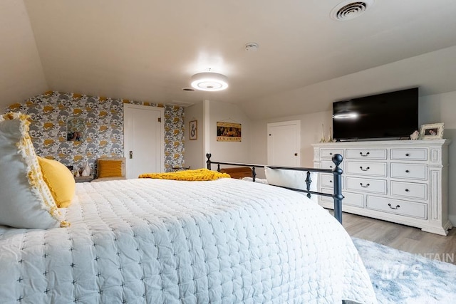 bedroom with wood-type flooring and lofted ceiling