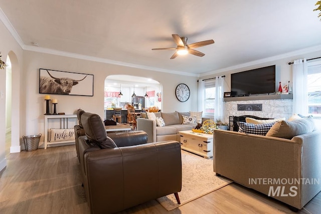 living room featuring a wealth of natural light, ceiling fan, ornamental molding, and hardwood / wood-style flooring