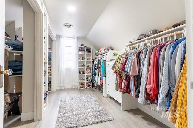 spacious closet featuring vaulted ceiling and light hardwood / wood-style flooring