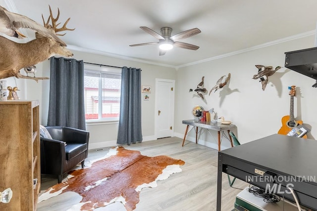 interior space with crown molding, ceiling fan, and light wood-type flooring