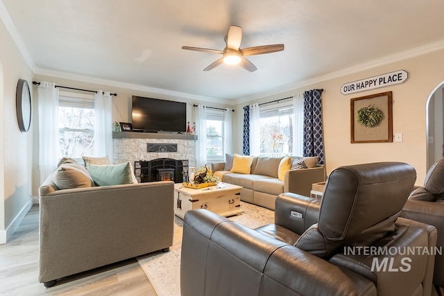 living room featuring ceiling fan, a healthy amount of sunlight, light wood-type flooring, and ornamental molding