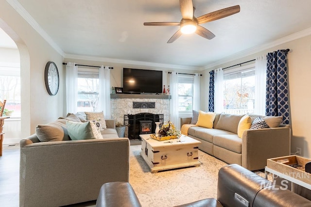 1302 1st Ave S, Payette, ID 83661 - living room with crown molding, plenty of natural light, a stone fireplace, ceiling fan, and arched walkways