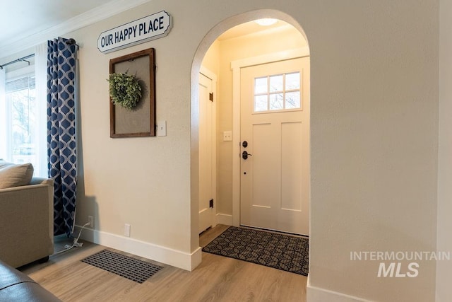 entryway featuring light hardwood / wood-style floors and crown molding