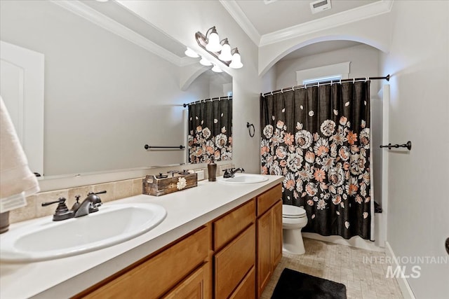 bathroom featuring visible vents, toilet, crown molding, and a sink