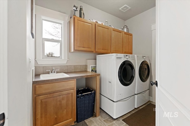 laundry area featuring visible vents, cabinet space, independent washer and dryer, and a sink