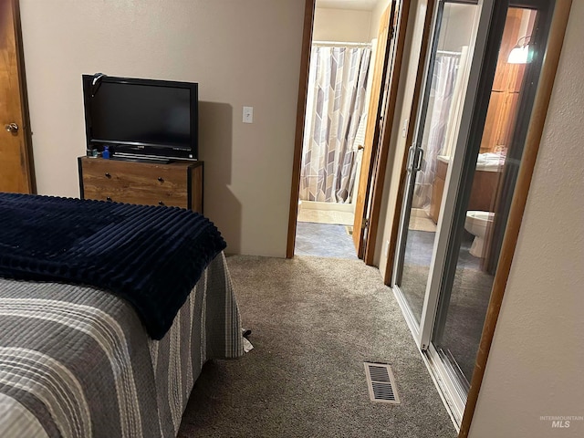 carpeted bedroom featuring ensuite bath