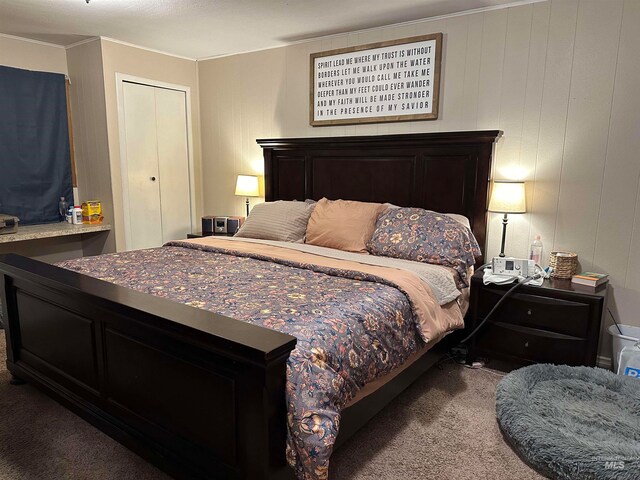 carpeted bedroom featuring a closet and crown molding