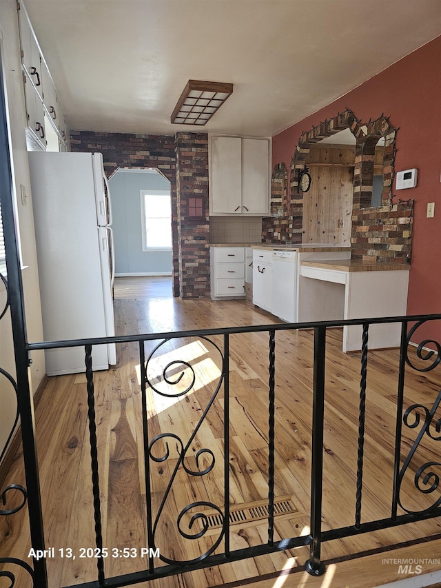 314 S Phillippi St, Boise, ID 83705 - kitchen featuring white appliances, white cabinetry, light wood-style flooring, arched walkways, and decorative backsplash