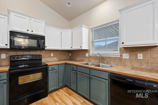 kitchen featuring black appliances, white cabinets, sink, light hardwood / wood-style floors, and lofted ceiling