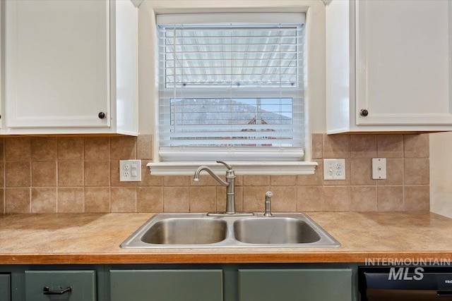 kitchen with sink, white cabinetry, dishwashing machine, and backsplash