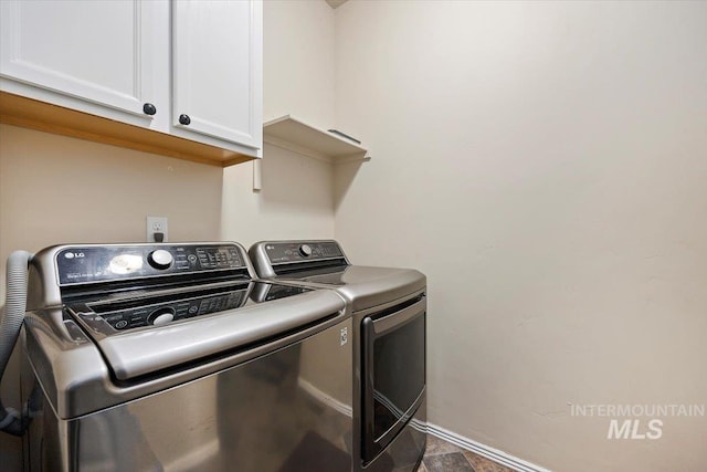 washroom featuring cabinets, washing machine and dryer, and tile patterned flooring