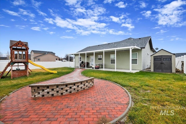 back of property with a patio, a yard, a shed, and a playground