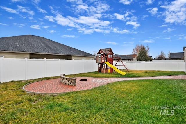 view of playground featuring a patio area and a yard