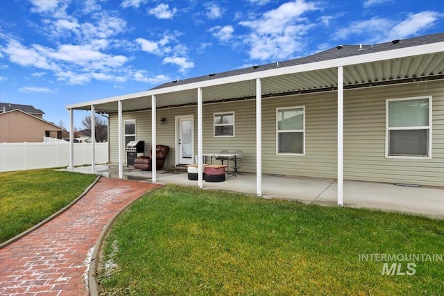 back of house with a patio area and a lawn