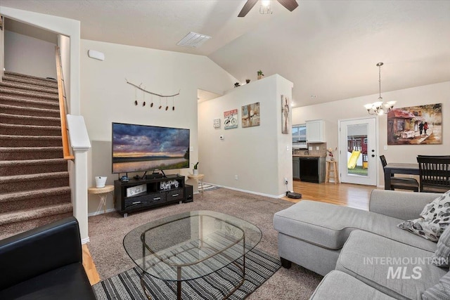 living room with ceiling fan with notable chandelier, lofted ceiling, and light colored carpet