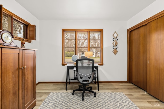 office with baseboards and light wood-style flooring