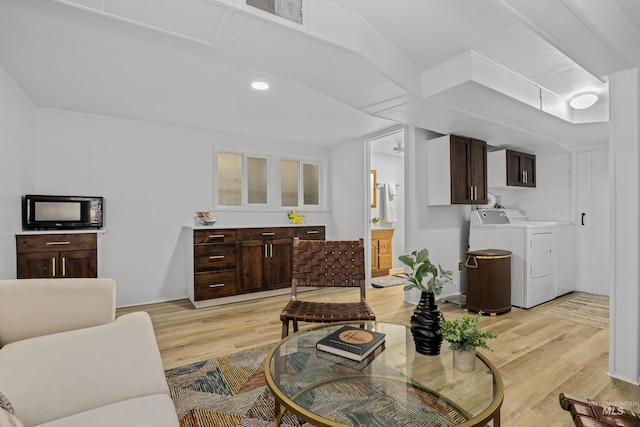 living room with light wood-style floors and washing machine and dryer