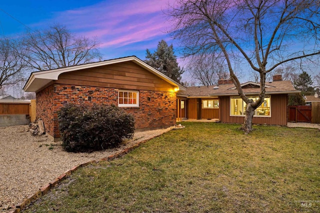 rear view of property with a lawn, fence, and a chimney