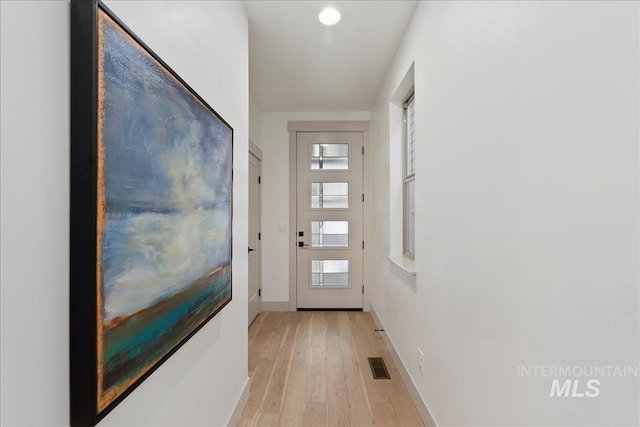 doorway to outside featuring visible vents, baseboards, and light wood-style floors