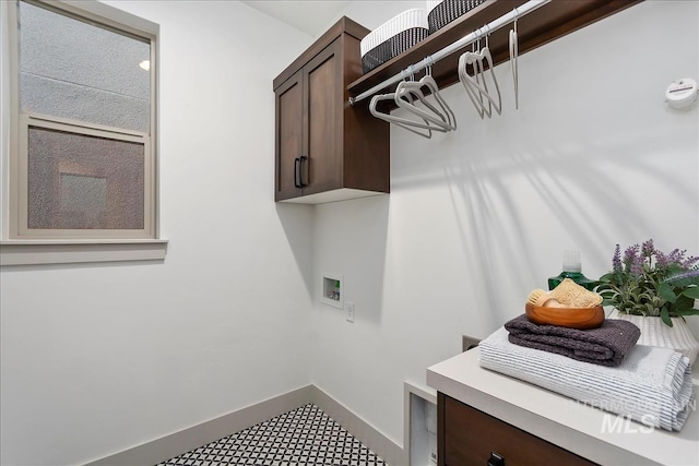 washroom featuring cabinet space, hookup for a washing machine, and baseboards