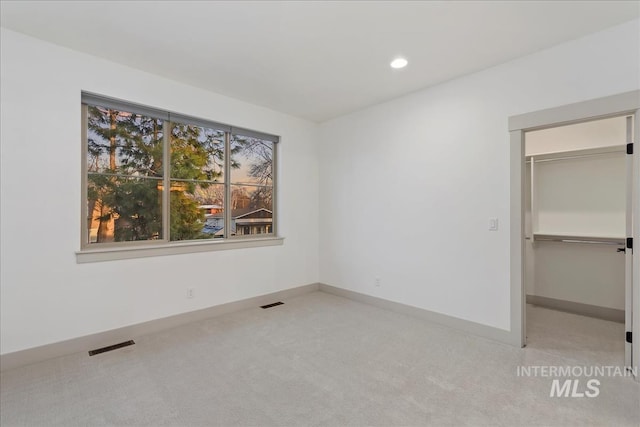 unfurnished bedroom with visible vents, recessed lighting, a closet, carpet flooring, and baseboards