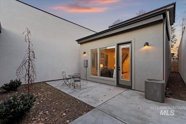 back of property with stucco siding, a patio, central AC unit, and fence