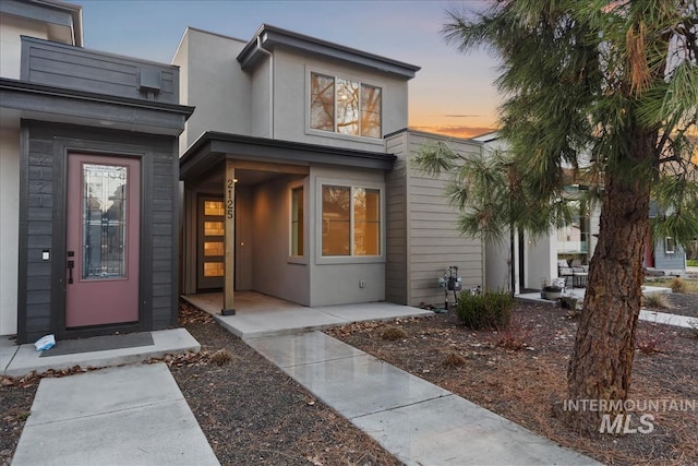 exterior entry at dusk with stucco siding