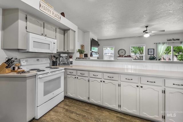 kitchen featuring white appliances, dark wood-style flooring, a textured ceiling, and ceiling fan