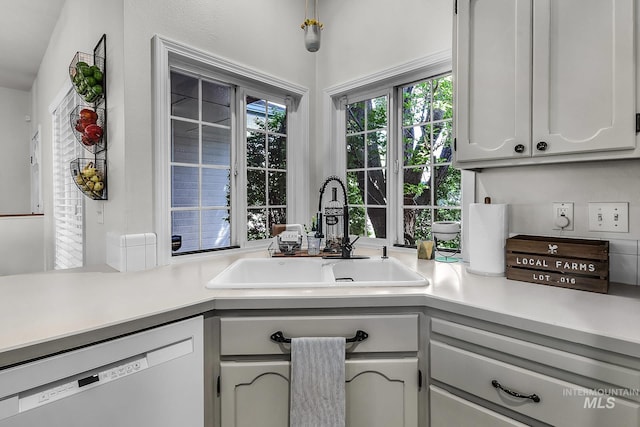 kitchen with a sink, light countertops, and dishwasher