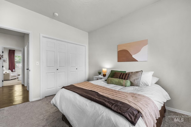 carpeted bedroom featuring baseboards and a closet