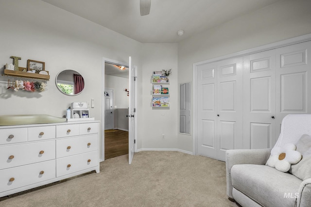 living area with baseboards, ceiling fan, and light carpet