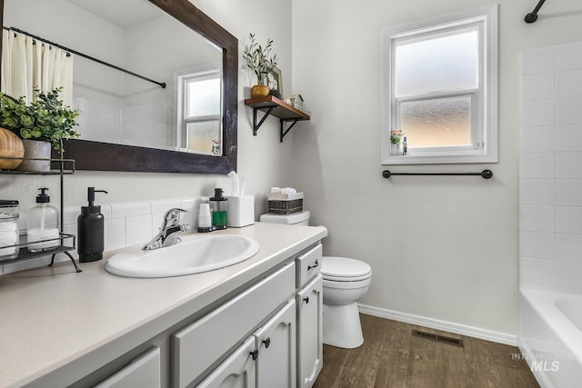 full bathroom featuring visible vents, vanity, wood finished floors, toilet, and baseboards