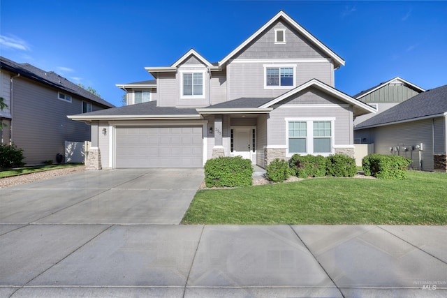 craftsman house with stone siding, concrete driveway, a front yard, and an attached garage