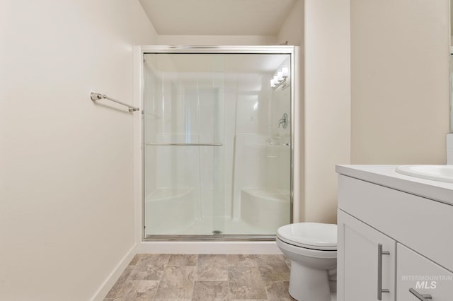 bathroom featuring vanity, toilet, and a shower with shower door